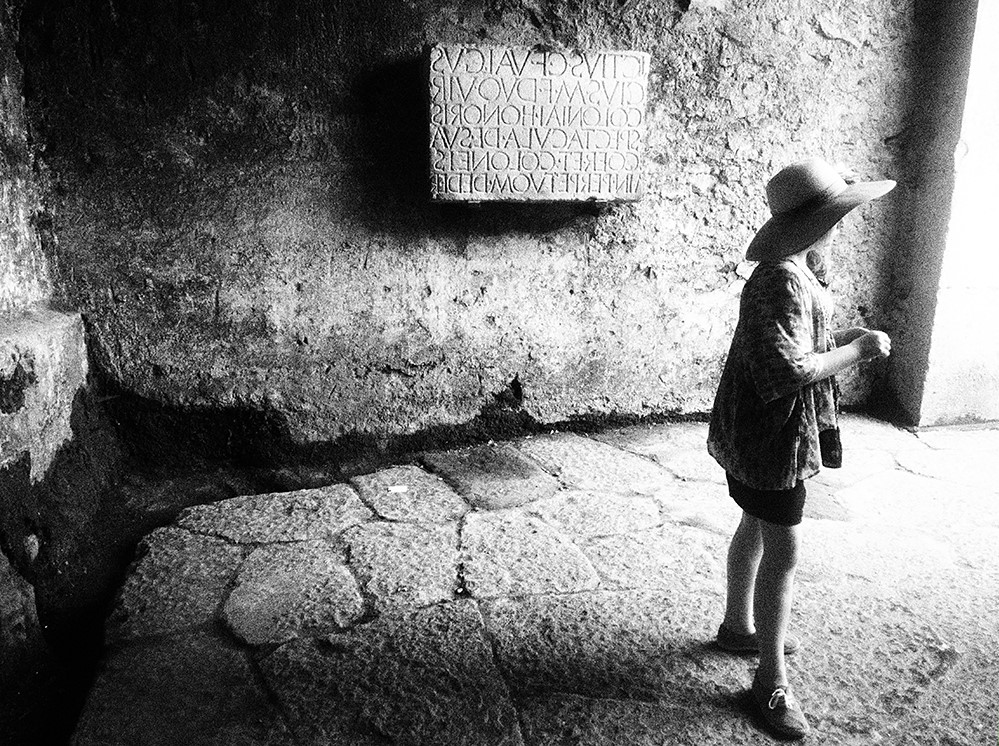 A young girl stands in the amphitheatre of Pompeii